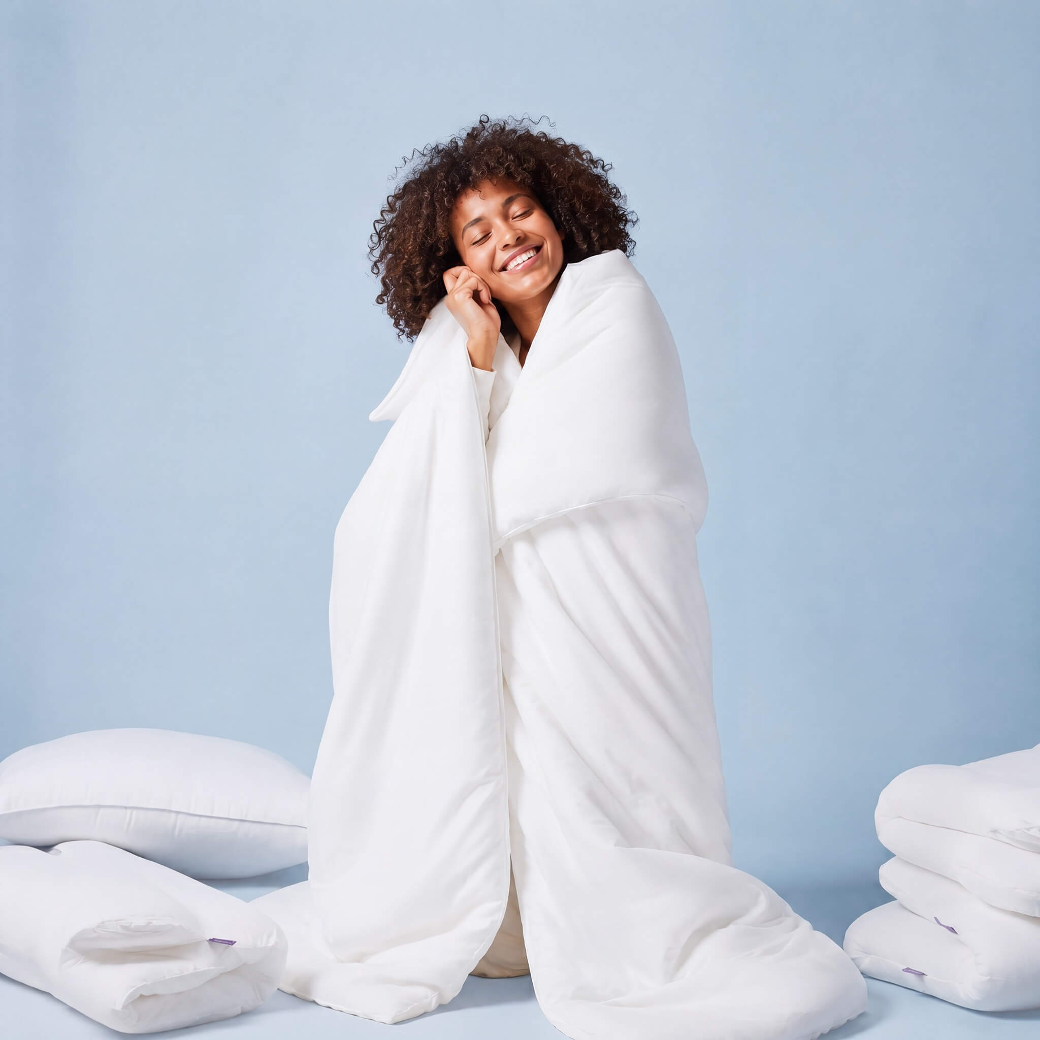 Woman wrapped in the soft white Cloud Puff Duvet, smiling
