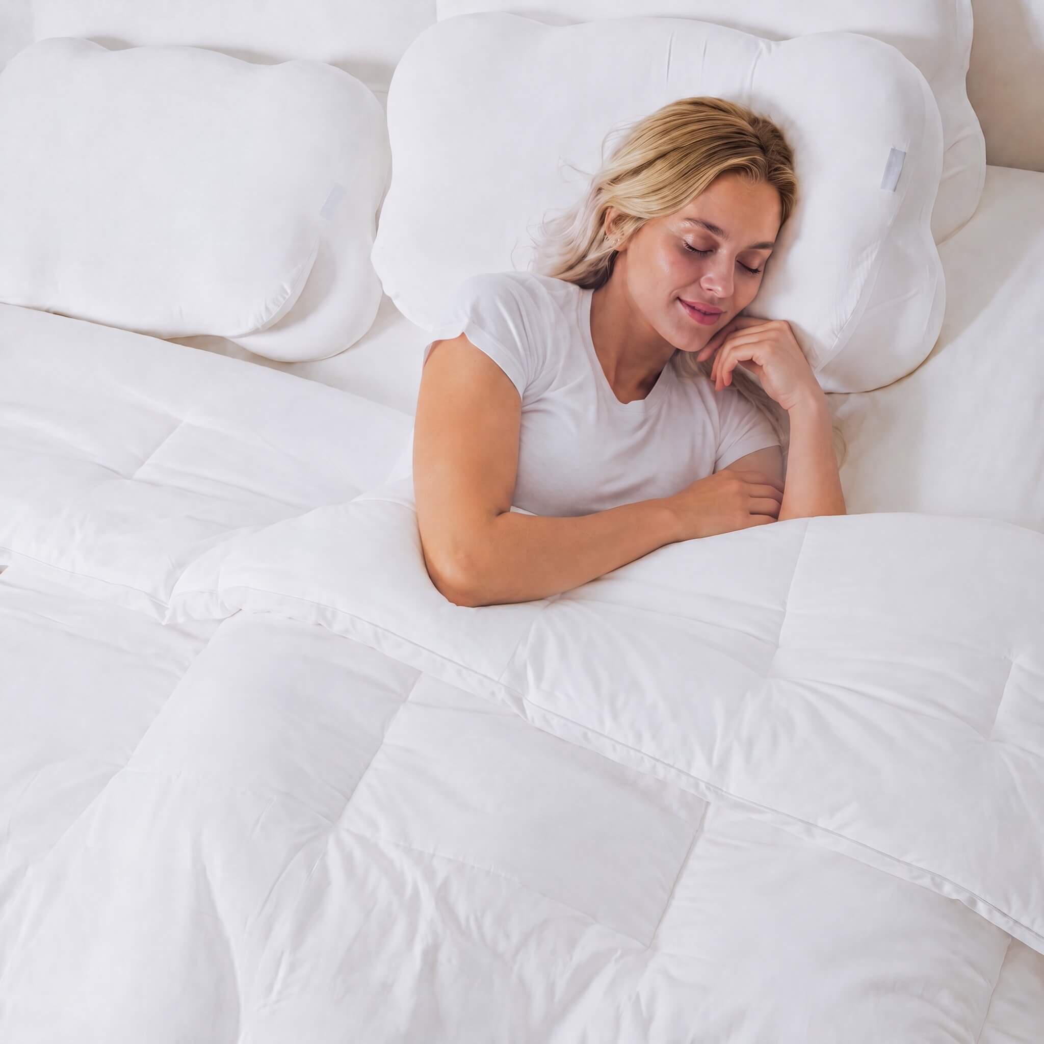 Woman sleeping cozily in bed under the soft white Cloud Puff Duvet